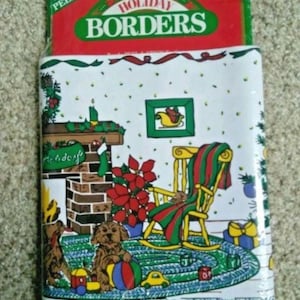 Könnte beinhalten: Weihnachtsbordürenrolle mit festlichem Design, das einen Kamin, einen Schaukelstuhl und Welpen zeigt. Die Verpackung trägt die Aufschrift "Abziehbar & selbstklebend" und "Einfach anzubringen - Einfach zu entfernen". Die Rolle misst ca. 16 cm x 4,57 m.