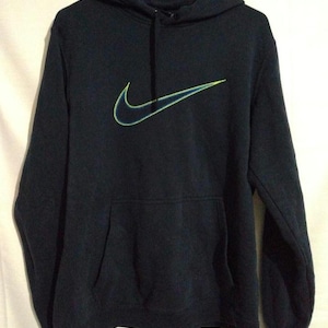 May include: A navy blue hoodie with a front pocket and a drawstring. The Nike logo is embroidered on the front in neon green and blue.