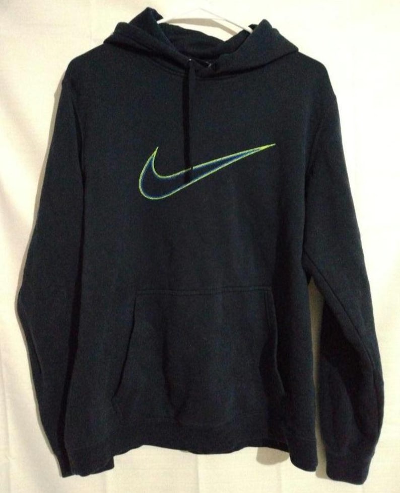May include: A navy blue hoodie with a front pocket and a drawstring. The Nike logo is embroidered on the front in neon green and blue.
