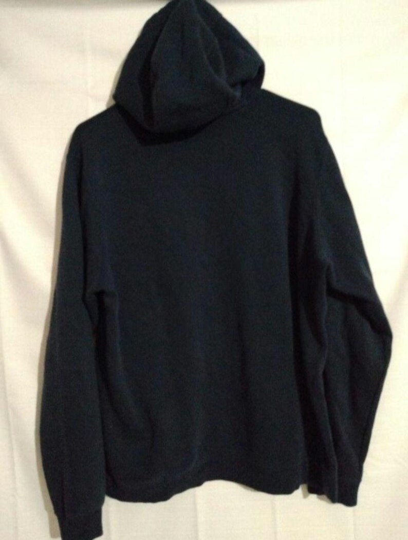 May include: A dark navy blue hooded sweatshirt. The sweatshirt features a hood and long sleeves. The garment is made of a soft material. The back of the sweatshirt is visible.
