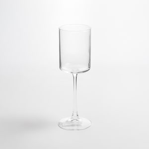 Puede incluir: Una copa transparente con un cuenco cilíndrico y un tallo delgado. La base es redonda y la copa está diseñada para bebidas. La copa está hecha de material transparente, lo que permite ver el contenido.