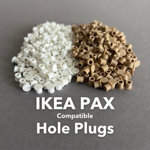 May include: A collection of white and tan hole plugs, designed to be compatible with IKEA PAX furniture. The image shows a pile of each color, with the text "IKEA PAX Compatible Hole Plugs" below.