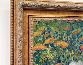 May include: A framed oil painting featuring a dense garden scene with vibrant green foliage, textured orange flower clusters, and prominent blue and white floral elements, enclosed in an ornate, metallic gold-toned decorative frame.