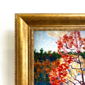 May include: A framed landscape painting with a gold ornate frame. The artwork depicts a vibrant autumn scene with red and orange foliage, a blue sky, and a dark green forest in the background. The painting is a close-up view of a tree.