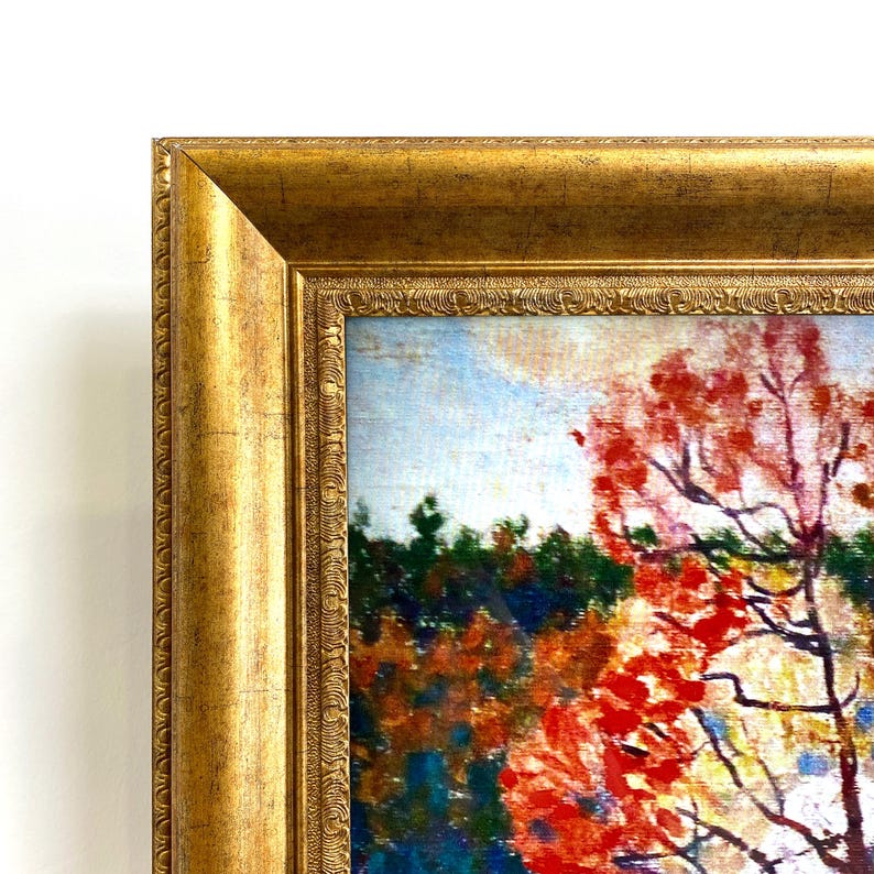 May include: A framed landscape painting with a gold ornate frame. The artwork depicts a vibrant autumn scene with red and orange foliage, a blue sky, and a dark green forest in the background. The painting is a close-up view of a tree.