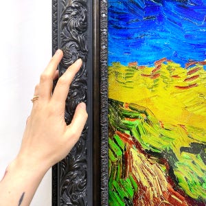 Pode incluir: Pintura emoldurada com uma cena de paisagem vibrante. A obra apresenta um céu azul brilhante, campos amarelos e colinas verdes. A moldura é escura com detalhes ornamentados.