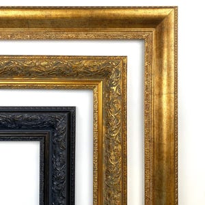May include: Close-up of three ornate picture frames. The largest frame is gold with a textured finish. The middle frame is also gold with detailed carvings. The smallest frame is black with intricate patterns, showcasing a classic design.