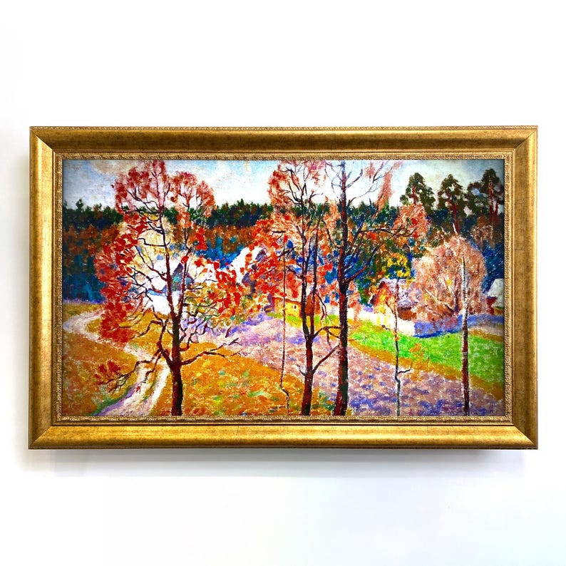 May include: A framed landscape painting with a gold-coloured frame. The artwork depicts a colourful autumn scene with trees in shades of red and orange, a winding path, and a village in the background. The painting is set against a white background.
