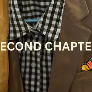 May include: A tan blazer with a black and white checkered shirt underneath, a yellow scarf, and a butterfly pin. The text "SECOND CHAPTER" is displayed across the image. The blazer is hanging on a hanger.