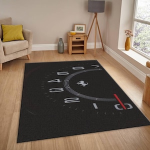 May include: A rectangular area rug featuring a black background with a large white graphic of a tachometer gauge. The design includes white numbers from one to seven, a red needle indicator, and a white prancing horse logo in the center.