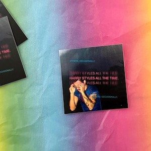 May include: Square sticker featuring a photo of a person with the text "HARRY STYLES ALL THE TIME." The sticker has a dark background with the words "OTHERS, OCCASIONALLY" at the top and bottom. The background is a rainbow of colors.