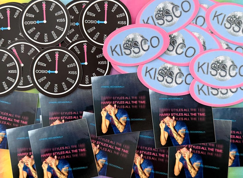 May include: A collection of stickers, buttons, and album art featuring the text "KISSCO" and "HARRY STYLES ALL THE TIME." The stickers have a disco ball design and clock face with the word "KISS." The album art features a person.