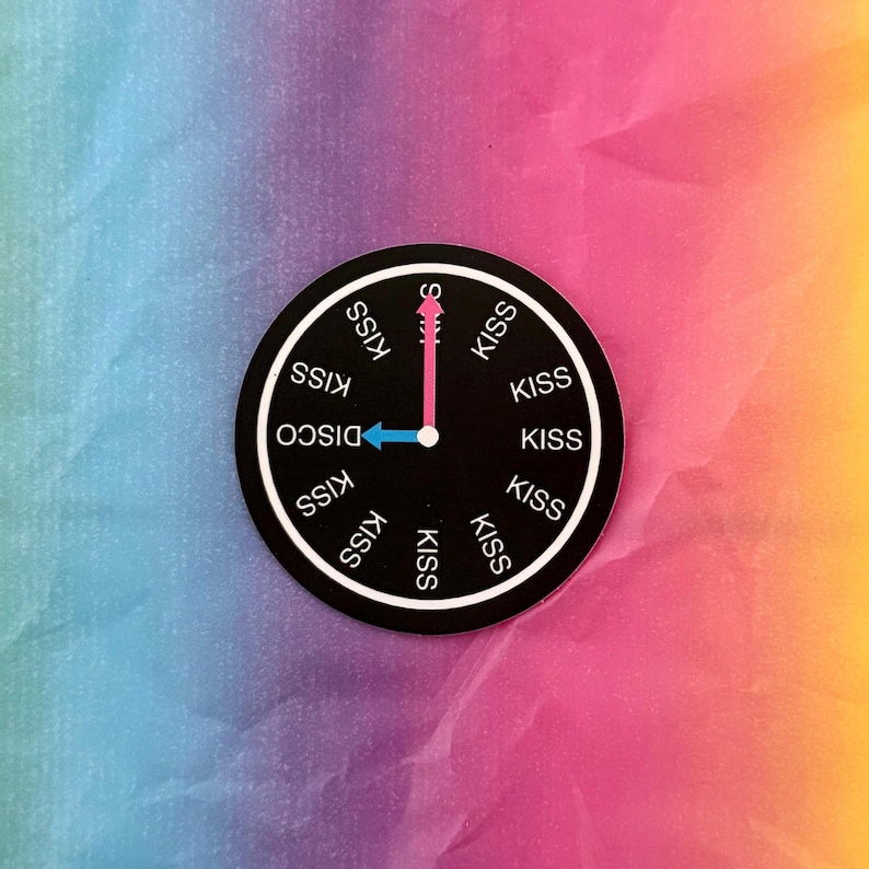 May include: A black circular sticker with a clock design. The clock face has the word "DISCO" and the word "KISS" repeated around the perimeter. The clock hands point to "S" and "DISCO". The background is a gradient of blue, pink, and yellow.