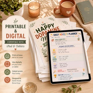 Może przedstawiać: Cyfrowy tablet wyświetlający Daily Novelty Planner z sekcjami na skupienie, harmonogramy i codzienne osiągnięcia, obok stosu wydrukowanych kartek z napisem The Happy Dopamine, kubka, świecy i notatnika na drewnianej powierzchni.