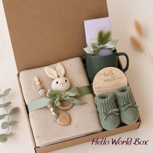 Curated newborn baby gift box with soft neutral and sage details, cozy baby essentials, bunny-inspired keepsakes, and thoughtful gifts for new parents. A beautiful baby shower gift basket, welcome baby gift box, new baby gift basket, new mom gift box, mom and baby gift, postpartum gift basket, and gender neutral baby gift for a newborn baby boy or girl.