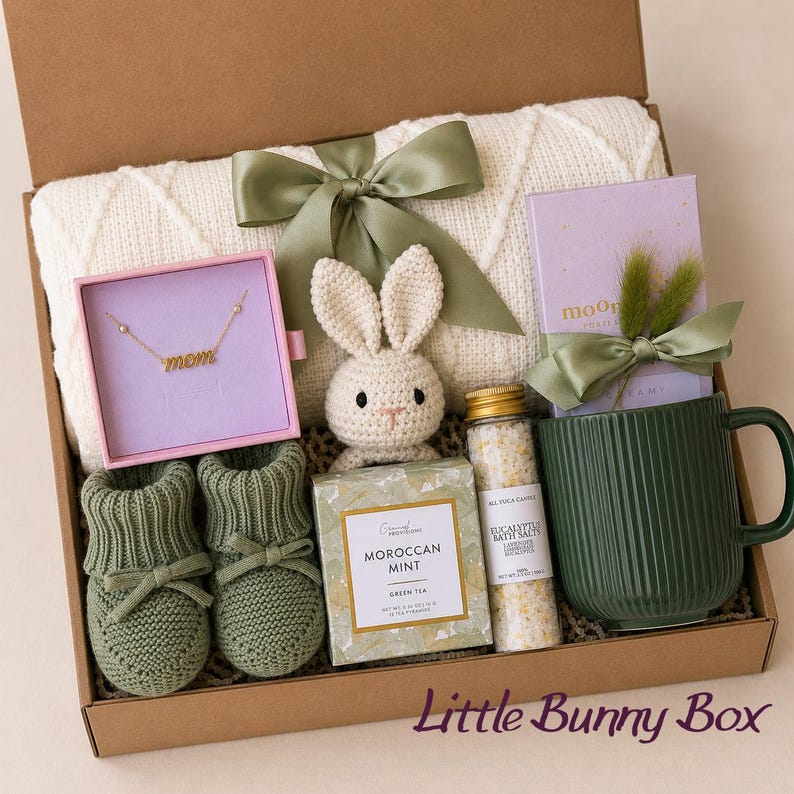 Curated newborn baby gift box with soft neutral and sage details, cozy baby essentials, bunny-inspired keepsakes, and thoughtful gifts for new parents. A beautiful baby shower gift basket, welcome baby gift box, new baby gift basket, new mom gift box, mom and baby gift, postpartum gift basket, and gender neutral baby gift for a newborn baby boy or girl.