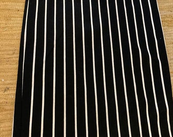 May include: Black and white striped skirt with a fitted silhouette. The skirt is made of a stretchy fabric and has a simple design.