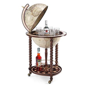 May include: A vintage-style globe bar cabinet with a hinged top, revealing a mirrored interior. The cabinet features a dark wood finish with intricate detailing, including turned legs and a lower shelf. It holds bottles and glasses.
