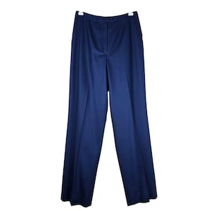 May include: Navy blue wide-leg pants hanging on a white hanger. The pants have a high waist and a button closure. The fabric appears to be a medium-weight material. A small orange tag is visible on the side of the pants.