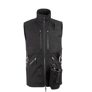 May include: Black vest with a high collar and multiple zippered pockets. Features a full-length zipper, a small pouch with a drawstring, and metal carabiner clips. The vest is designed for outdoor activities.