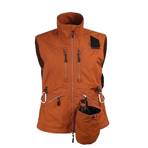 May include: Rust-colored vest with multiple zippered pockets and a high collar. Features a black patch on the shoulder and a detachable pouch with a drawstring closure. Includes white carabiner clips for attaching accessories.
