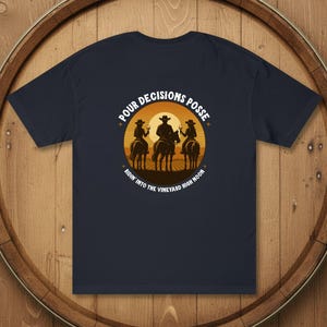 May include: Navy blue t-shirt with a graphic of three people on horseback holding wine glasses, silhouetted against a sunset. Text reads "Pour Decisions Posse" and "Ridin' into the Vineyard High Moon."