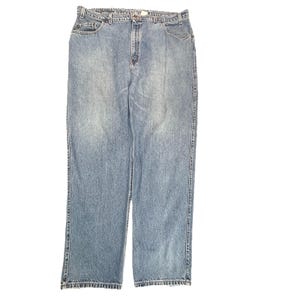 May include: A pair of light blue denim jeans featuring a classic five-pocket design, a button and zipper fly closure, belt loops at the waistband, and a straight-leg cut with visible stitching along the seams and a faded wash finish.