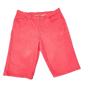 May include: Bright red denim shorts with a classic five-pocket design. The shorts have a button and zipper closure and are made of a sturdy denim material. The shorts are knee-length.