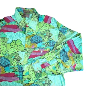 May include: A button-down shirt with a vibrant, all-over print. The design features stylized figures, clouds, and geometric shapes in shades of green, blue, pink, and yellow. The shirt has a collared neckline and long sleeves.