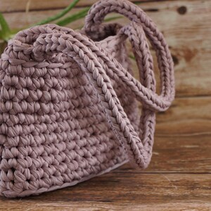 Crochet tote bag with braided handle detail showing thick woven strap construction