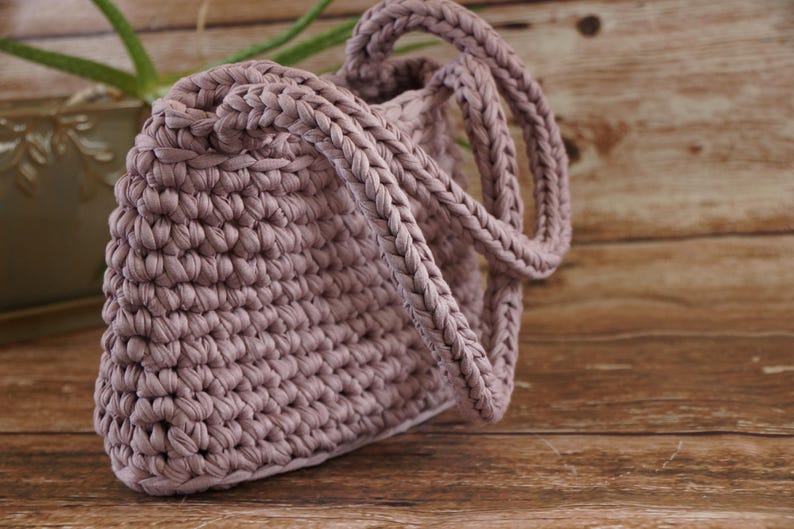 Crochet tote bag with braided handle detail showing thick woven strap construction