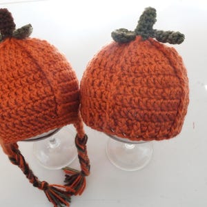 Two crochet pumpkin hat pattern samples with earflaps and braided ties, shown right-side up with leaf stem toppers on top