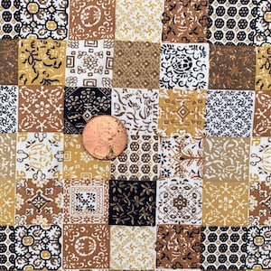 May include: A patchwork fabric with a variety of square patterns in shades of brown, gold, black, and white. The patterns include floral, geometric, and abstract designs. A penny is placed on the fabric for scale.