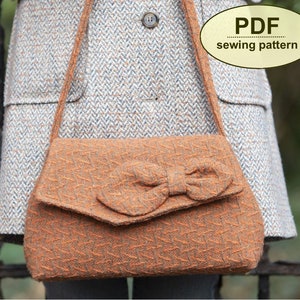 Könnte beinhalten: Eine braune Tweed-Handtasche mit einer großen Schleife auf der Klappe. Die Tasche hat einen langen Riemen und wird über der Schulter getragen. PDF-Schnittmuster.