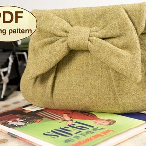 May include: A PDF sewing pattern for a green felt clutch with a large bow on the front. The clutch is sitting on a book with the title "The Best of the 1960s" on the cover.