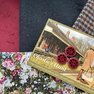 May include: A selection of fabrics and sewing notions. The image shows a floral print, corduroy, and tweed. The card reads "Charlie's Aunt" and there are three red buttons.