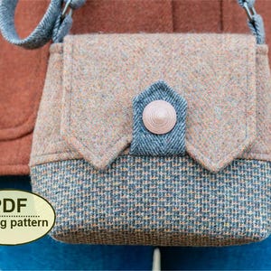 May include: A small, tweed crossbody bag with a flap closure. The bag features a mix of tan, blue, and gray fabrics, with a button closure. The words "PDF sewing pattern" are in a yellow oval at the bottom. The bag has a gray strap.