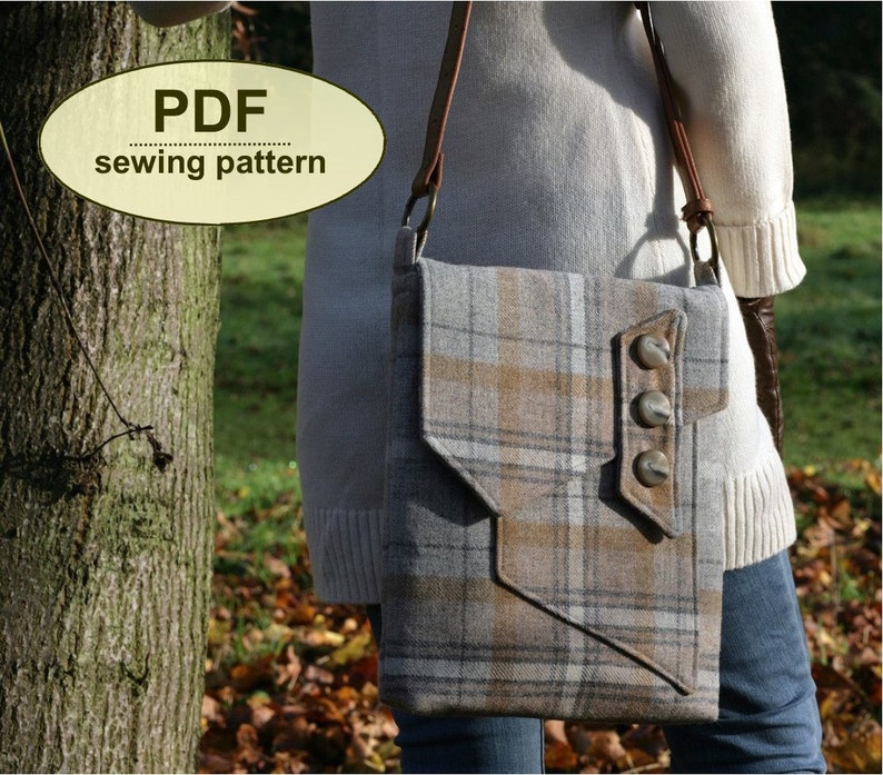 May include: A plaid crossbody bag with a flap closure and three large silver buttons. The bag is made of a brown and gray plaid fabric and has a brown leather strap.