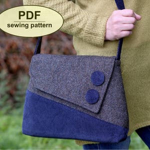 May include: A PDF sewing pattern for a blue and brown tweed crossbody bag with two large blue buttons. The bag is being worn by a person wearing a yellow jumper.