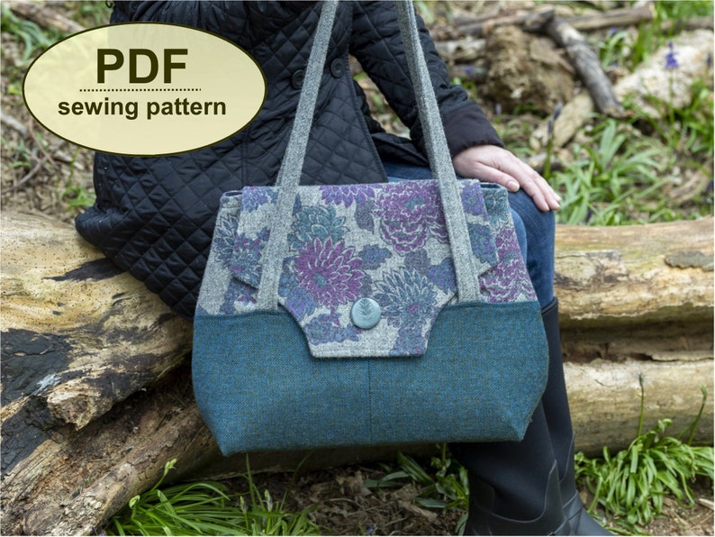 May include: A PDF sewing pattern for a tote bag with a floral print fabric. The bag has a teal blue bottom and a gray top with a floral print. The bag has a button closure.