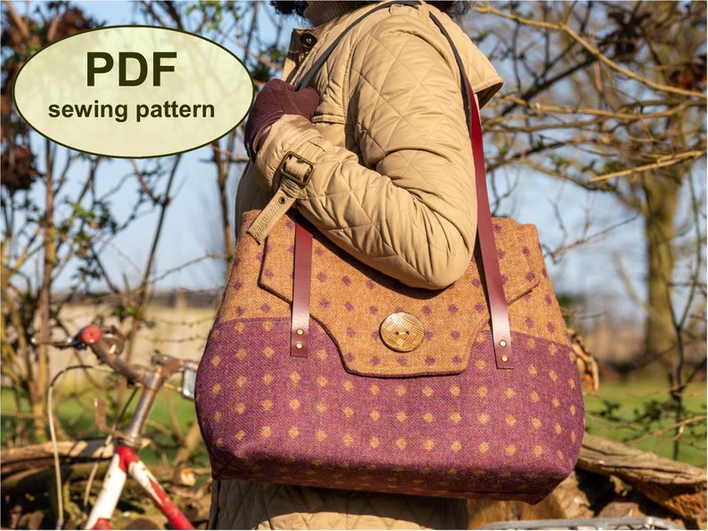 May include: A PDF sewing pattern for a brown and purple tweed tote bag with a leather strap and a large wooden button. The bag is being held by a person wearing a brown jacket.