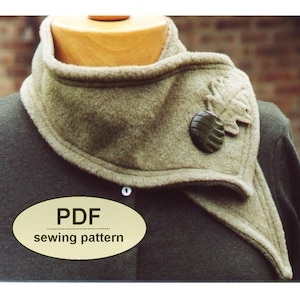 May include: A tan fleece cowl neck warmer with a leaf and button embellishment. The cowl is displayed on a mannequin and has a pointed front. The text "PDF sewing pattern" is in a cream oval.