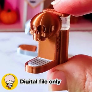 Może przedstawiać: Miniaturowy ekspres do kawy w kolorze miedzi ze szczytem w kształcie czaszki. Słowa "Digital file only" są wyświetlane białym tekstem na żółtym okręgu u dołu. Ekspres do kawy ma przezroczysty zbiornik na wodę.