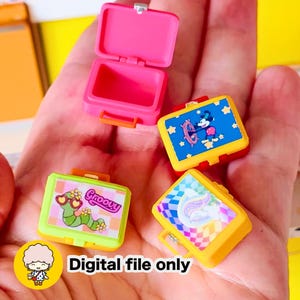 Puede incluir: Una colección de fiambreras en miniatura y coloridas. Una está abierta, revelando un interior rosa. Las otras presentan diseños que incluyen un personaje de dibujos animados, un gusano groovy y un unicornio arcoíris. También se ve el texto "Digital file only".