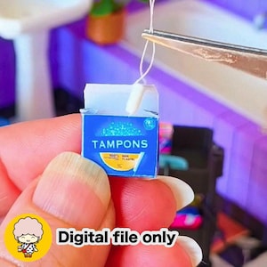 May include: Miniature blue box of tampons with the word "TAMPONS" in white. The box has a yellow and white design at the bottom and the text "100% NON PLASTIC". The text "Digital file only" is at the bottom.