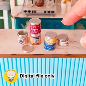 May include: A collection of miniature coffee tins featuring various brand labels including Folgers and Zodiac, displayed on a counter. The set includes several small cylindrical containers with silver lids, some stacked, alongside a digital file only label.