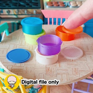 May include: Miniature plastic food containers in blue, green, orange, purple, and white. The containers have lids and are stacked on a round table. The text "Digital file only" is visible.