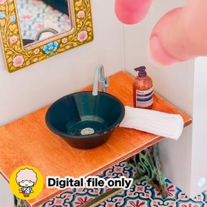 Op de afbeelding: Miniatuur badkamer scène met een donkerblauwe wastafel, een zilveren kraan en een kleine fles zeep. Een witte handdoek ligt op het houten aanrecht. De tekst "Digital file only" is zichtbaar. Een bloemenspiegel hangt aan de muur.