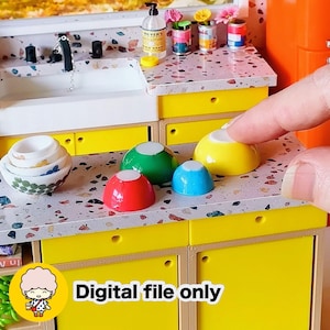 May include: Miniature kitchen set with a white sink, yellow cabinets, and colorful bowls. The countertop has a speckled design. The image includes the text "Digital file only".