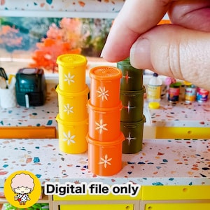 May include: Miniature yellow, orange, and green containers with white flower designs. The containers are stacked in groups of three. The image includes the text "Digital file only".